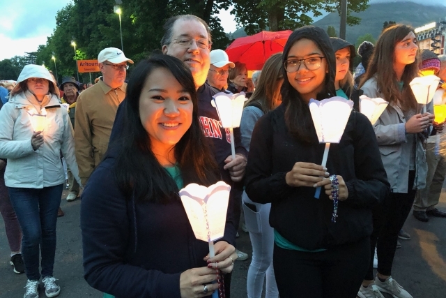 Paul Espiritu, Samantha Melendez, Keyla Peyano, and Theresa Vogel holding candles with Fr. Holliday
