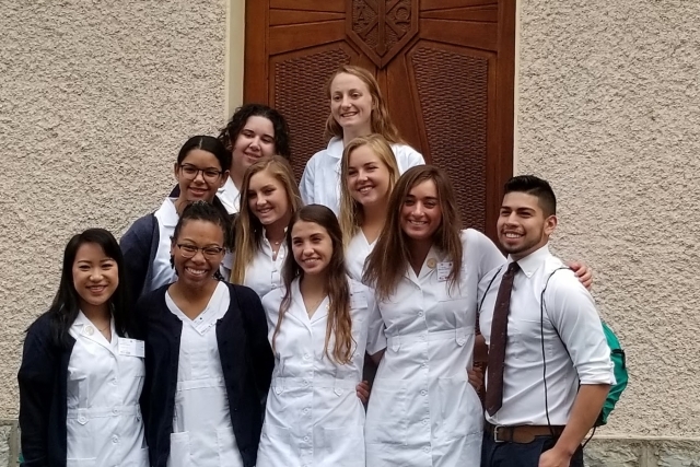 Paul Espiritu, Samantha Melendez, Keyla Peyano, and Theresa Vogel posing with other students for photo infront of building