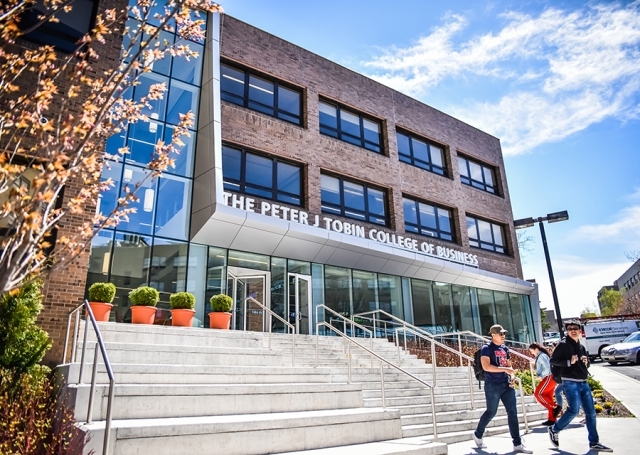 Exterior of the Peter J Tobin College of Business building with students walking outside