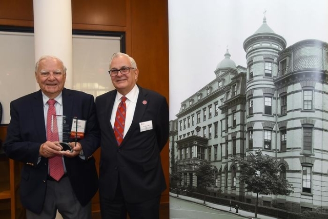 Two gentleman posing next to old St. John's building