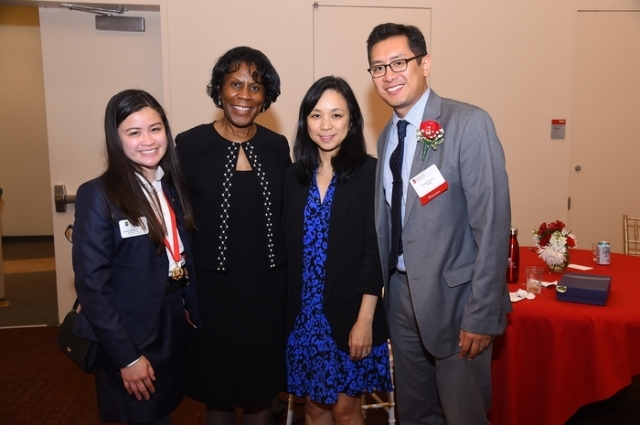 Group of 4 adults posing for photo at Alumni event