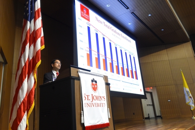 President Gempesaw standing at podium with chart on screen