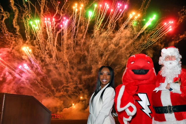 Student, Johnny and Santa standing infront of fireworks
