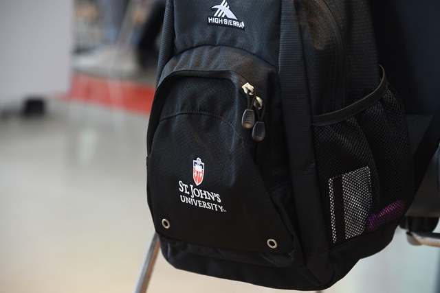 St. John's University logo on black backpack