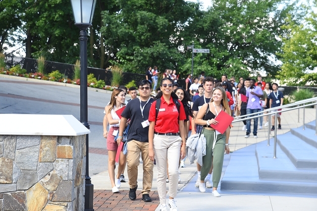 Students and orientation leader walking on campus