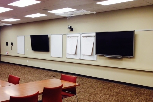 Wall with tv screens and white postit boards