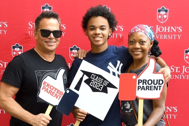 Family of three holding photo booth props