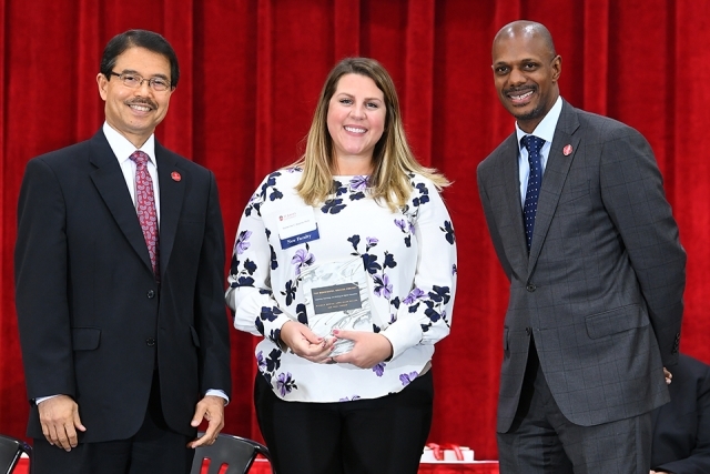 Dr Gempesaw, new female faculty member and the school dean posing for photo on stage