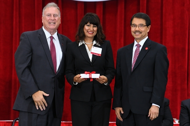 Dr Gempesaw, new female faculty member and the school dean posing for photo on stage