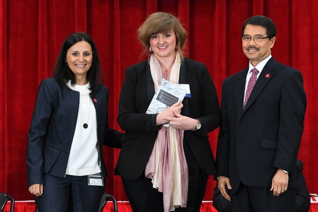Dr Gempesaw, new female faculty member and the school dean posing for photo on stage
