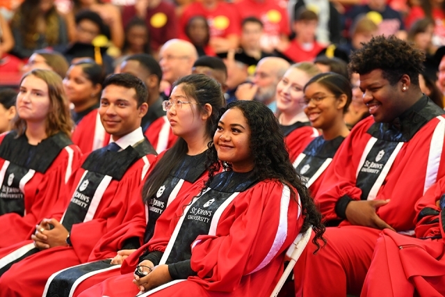 Chorus students sitting at ceremony smiling