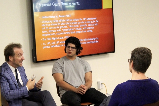Students and faculty sitting in a circle talking