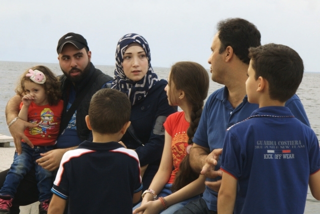 Group of 7 family members huddled together talking to one another