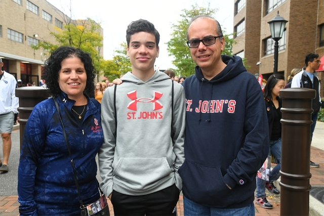 A family smiels for the camera in SJU clothing