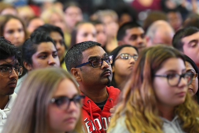 Faces in the crowd listening to Father Tracey