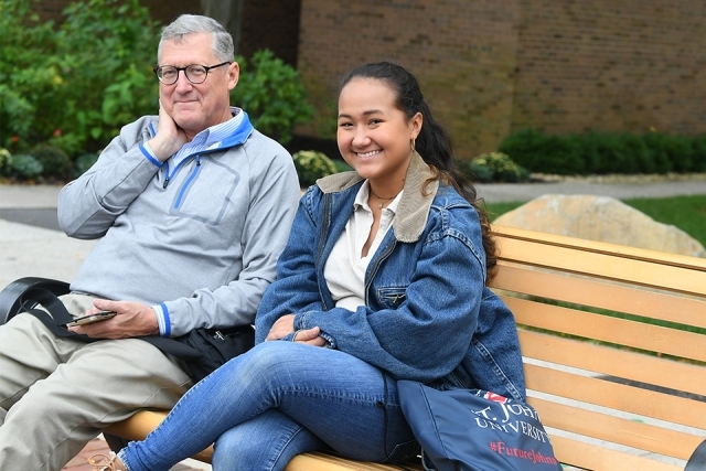Father and daughter on bench smiling