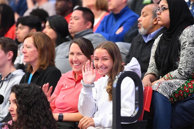 Guest waving at camera from welcome program crowd