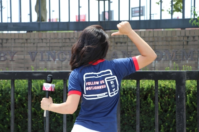 Female pointing to social media icons on back of t-shirt