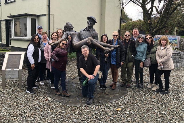 Alumni and Friends in Ireland posing by statue