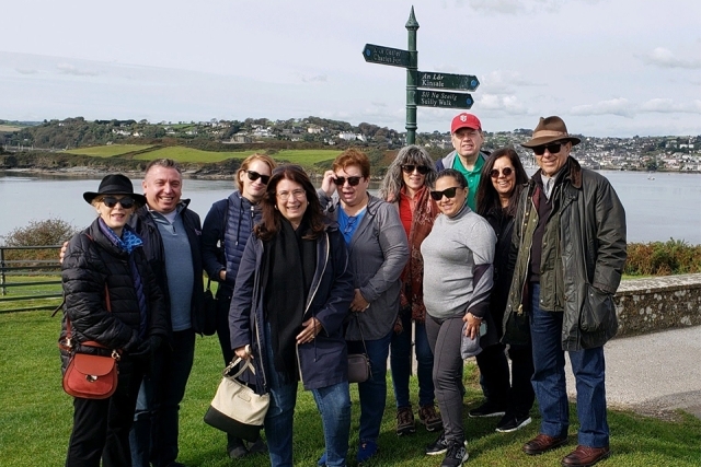 Alumni and Friends taking a picture by a street post