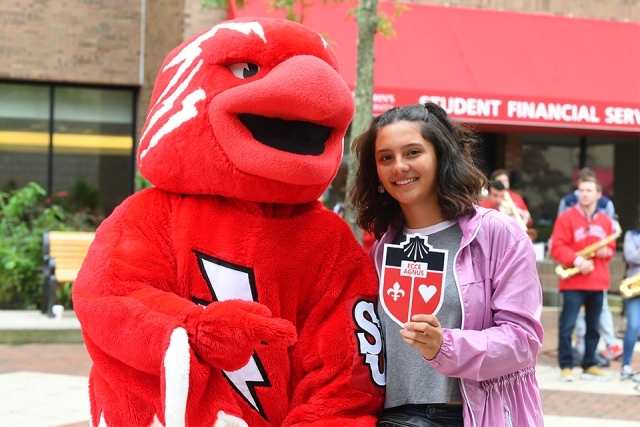 Johnny mascot and guest showing SJU crest
