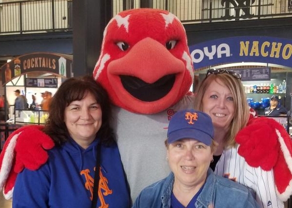 Johnny Thunderbird posing with 3 females in baseball stand