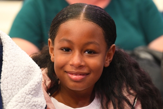 Young guest smiling in welcome program crowd