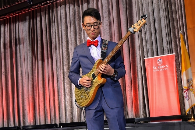 Musician playing guitar onstage at the President's Dinner