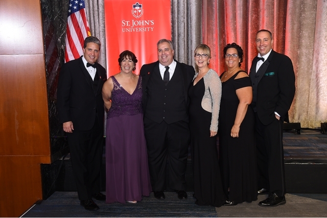 Six guests pose for a picture onstage at the St. John’s University 2019 President’s Dinner