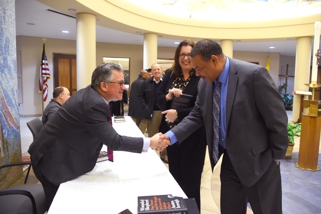 Austen Ivereigh shaking hands with lecture attendees
