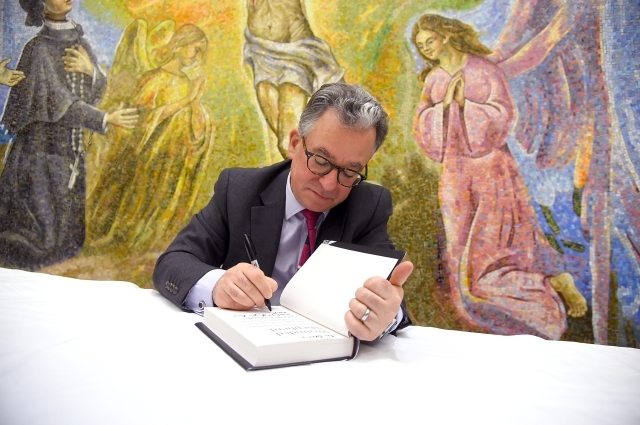 Austen Ivereigh signing a copy of his book