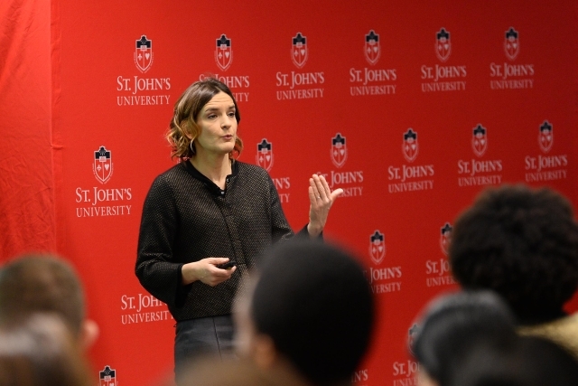 Esther Duflo Speaking in front of St. John's step-and-repeat