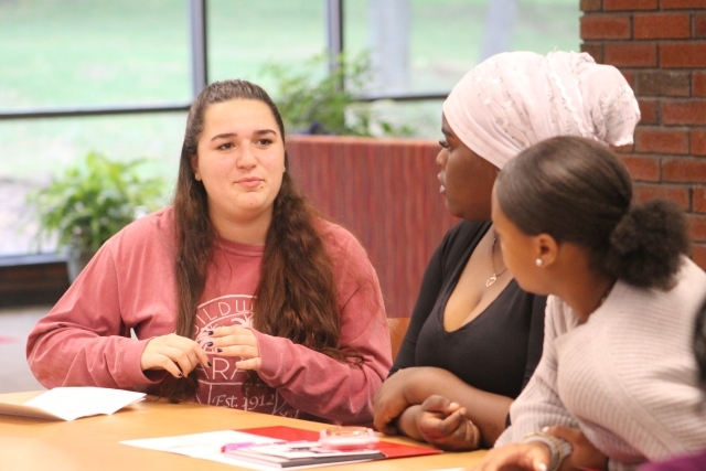 An SJU student facilitates a writing group with young female high school students
