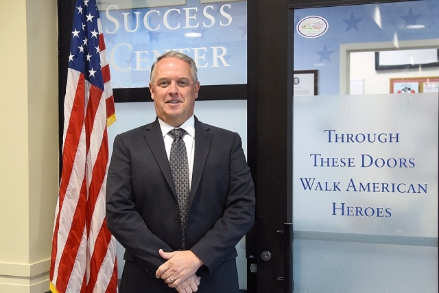 Kevin J. Killea ’88CBA standing next to the American flag