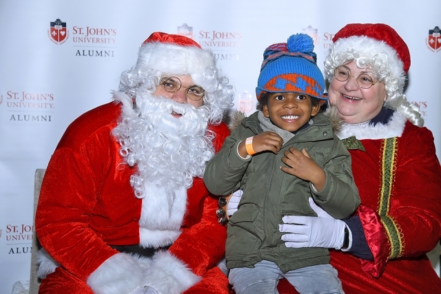 Santa and Mrs. Claus pose for a photo with child