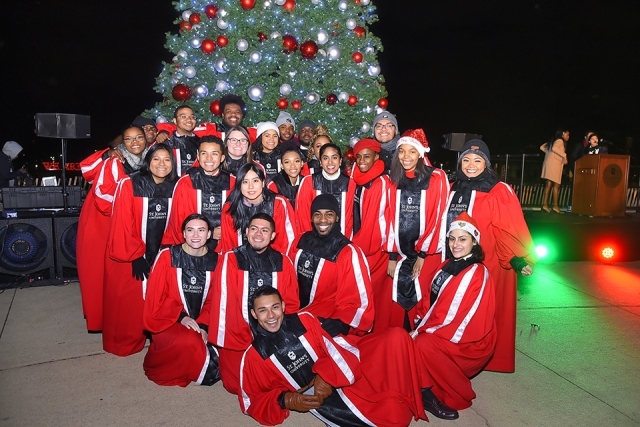 Voices of Victory pose for a photo in front of the Christmas tree