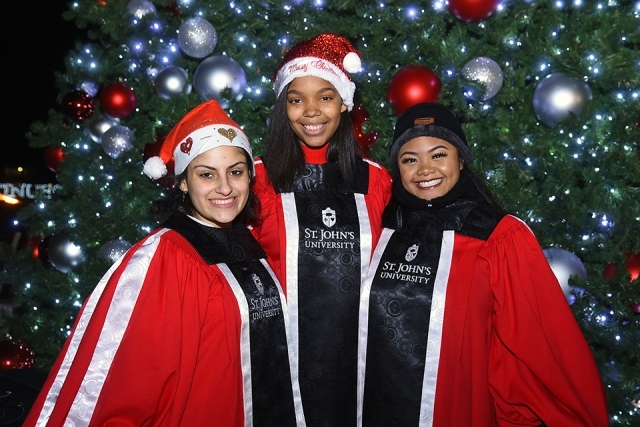 Students posing for a photo in front of the Christmas tree