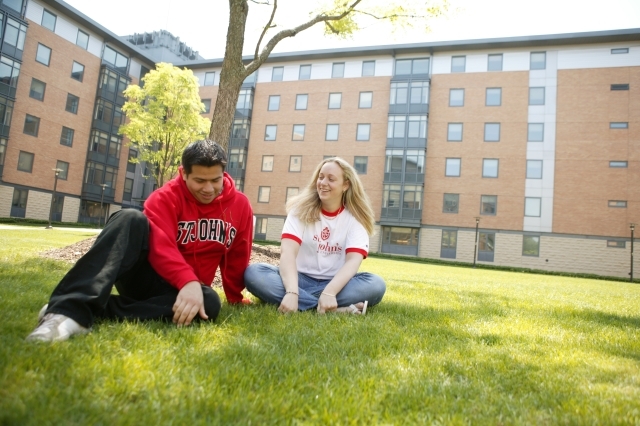 Exterior of Residence Halls with students sitting on lawn