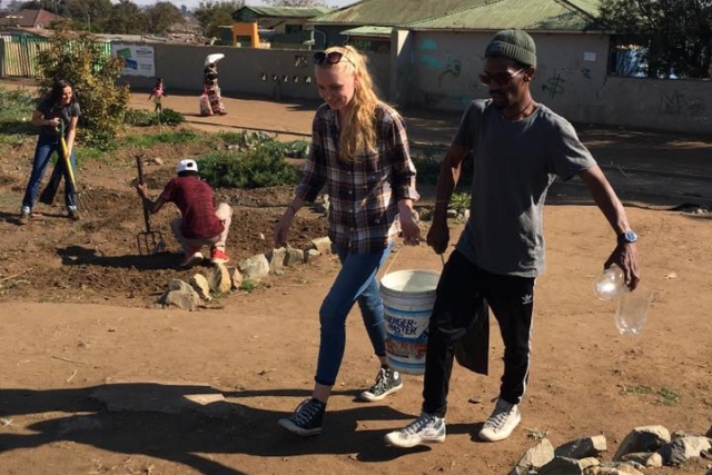 Two people carrying a bucket