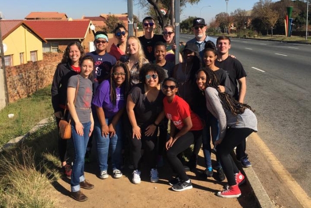 Students pose in front of Soweto road sign