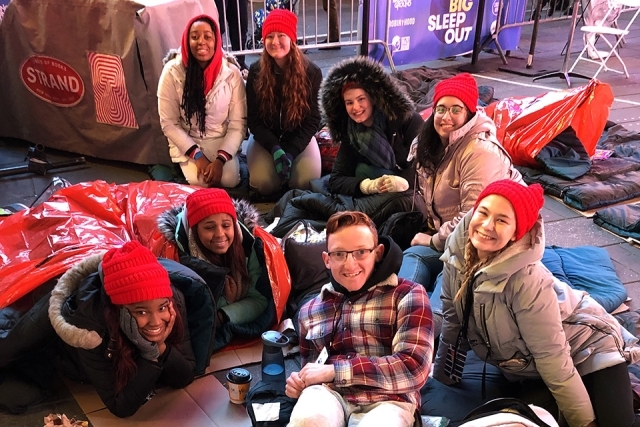 St. John's students sitting and laying on the ground in Times Square