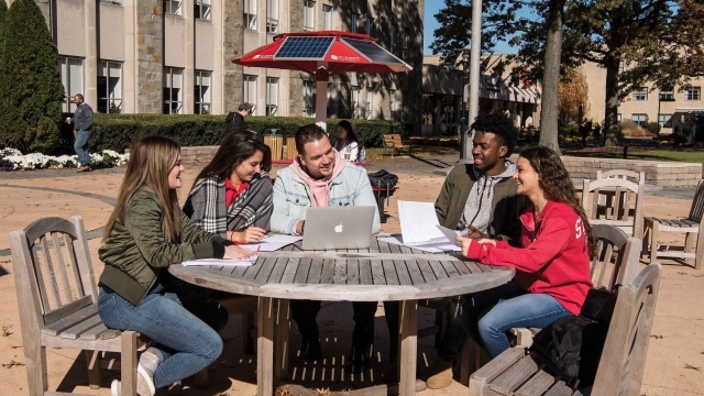 Students sitting at table outside talking