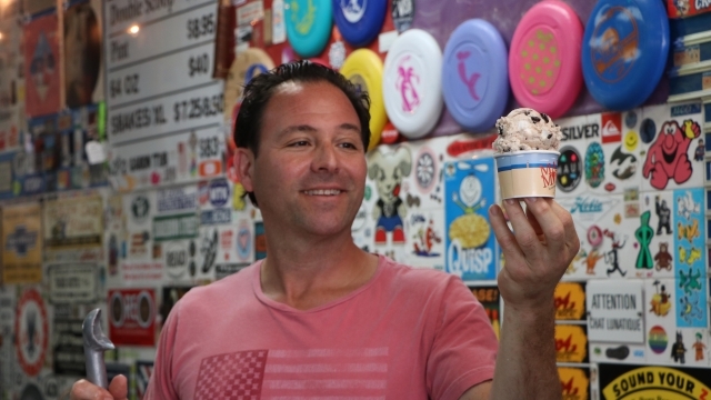 Owner of Max & Mina's holding ice cream cup