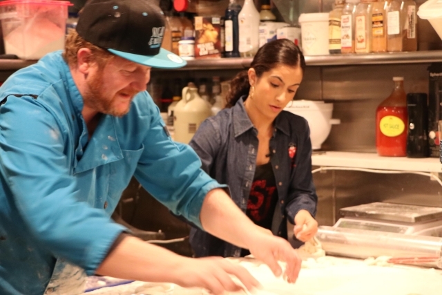 Kristen and the owner making dough together