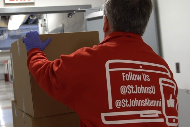 Male pushing boxes on cart