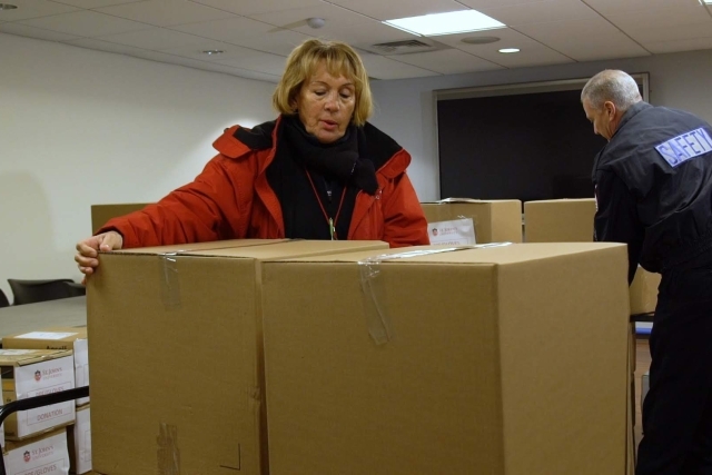 Public Safety officer loading boxes onto cart