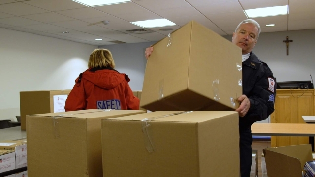 Public Safety officer loading boxes onto cart