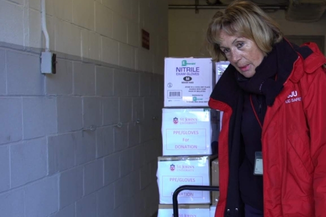Public Safety officer wheeling boxes on cart