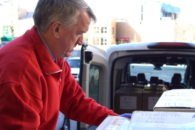 Public Safety officer loading boxes onto cart