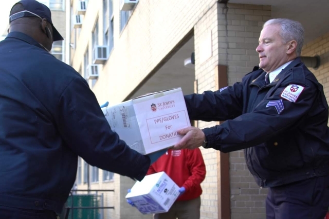Public Safety officer handing boxes to male
